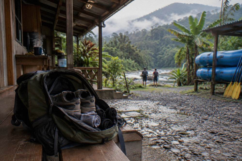 A dry pair of sneakers and rolled socks packed in an open daypack beside a river