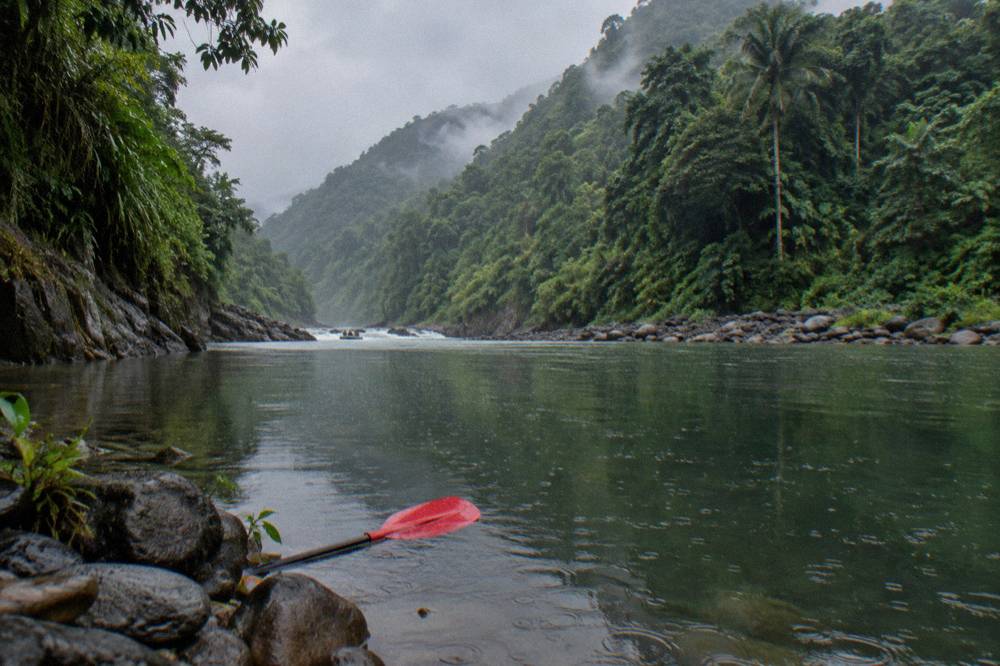 A calm pool between rapids reflecting green canyon walls on the Pacuare River