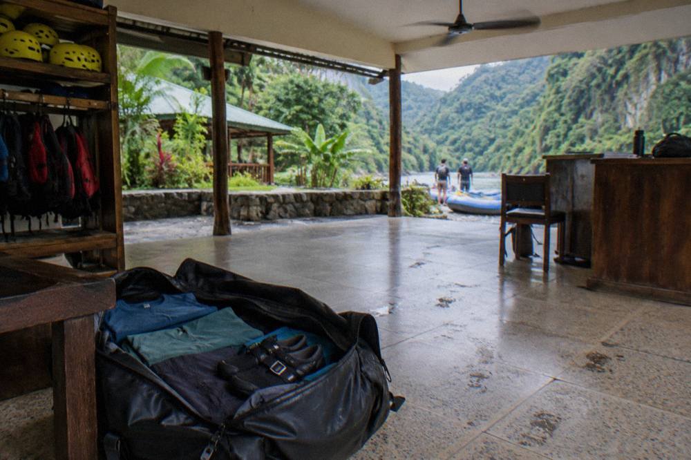 Pile of folded quick-dry shirts, synthetic shorts and secure river shoes packed in a duffel bag