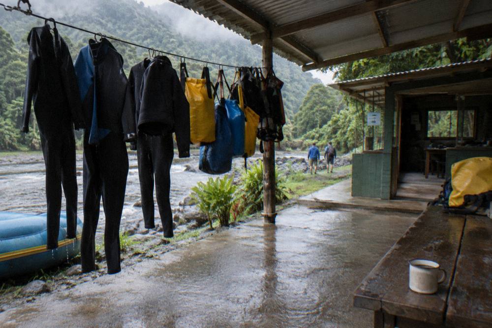 Dry bags hanging to dry on a line at a riverside rafting base