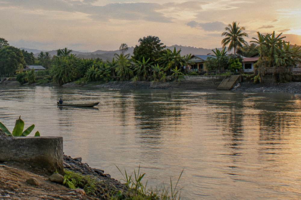 A calm wide river at the edge of a lowland town at the end of a gorge