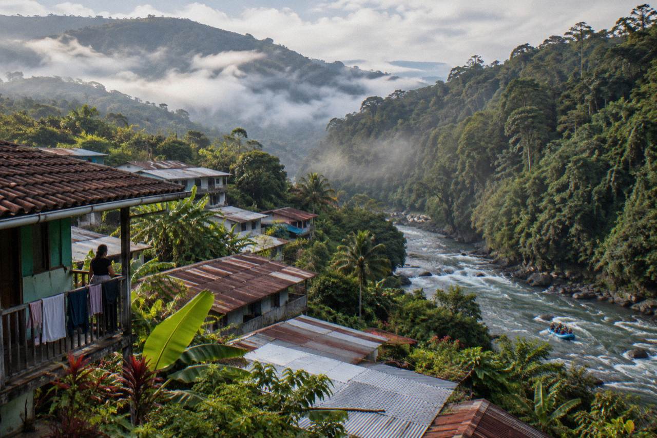 Green mountain town surrounded by cloud forest and volcano slopes at dawn