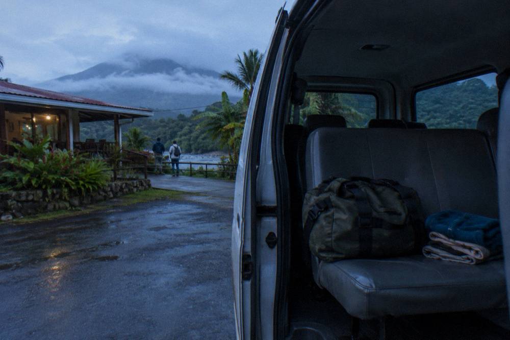 A packed duffel bag and spare clothes folded on the seat of a tour van