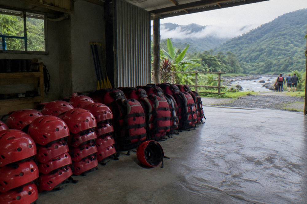 Helmets and life jackets stacked ready for a rafting trip at a river center